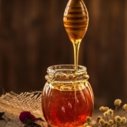 runny honey dripping from spurtle into jar
